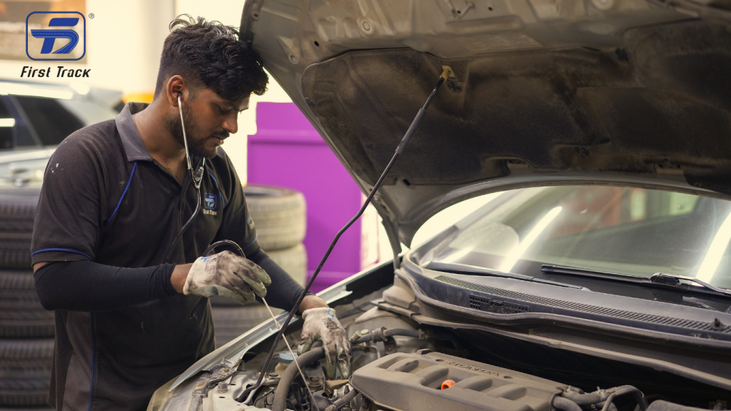 Mechanic performing an engine oil change at a professional car service center in Sharjah to prevent engine damage and overheating.