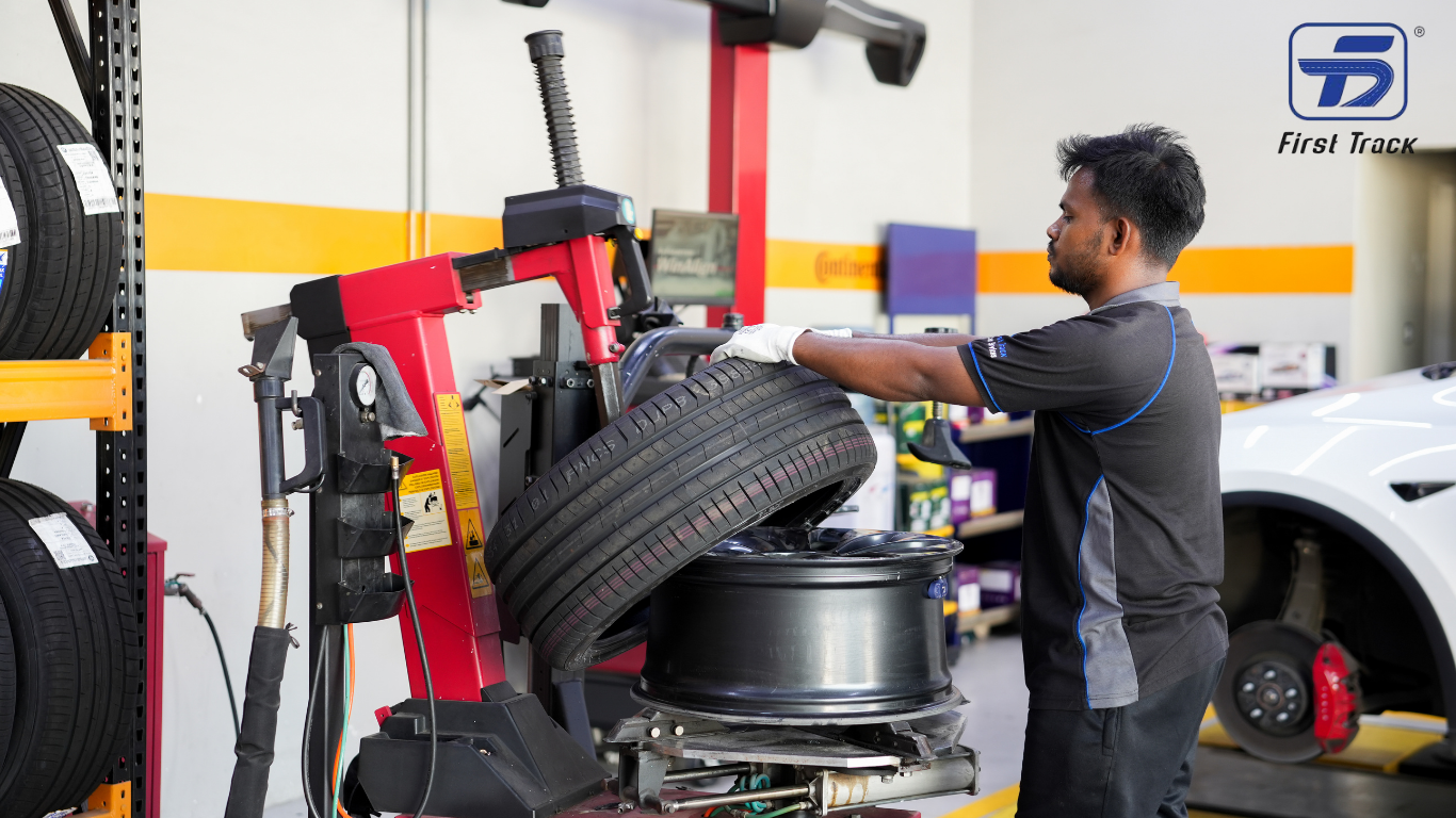 Technician performing professional tyre fitting and wheel service at Firsttrack Ajman using advanced tyre changing equipment